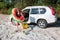 happy woman getting out from the car in flippers with inflatable ring and bag