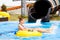 Happy woman going down on the rubber ring by the orange slide in the aqua park. Summer Vacation.