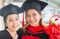 Happy woman graduate hand holding flower bouquet at graduate ceremony, Student graduating school with a cap and gown