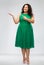 Happy woman in green pointing fingers at something