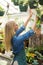 Happy woman hanging potted plants