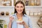 Happy woman having breakfast alone in kitchen, eating cereals