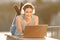 Happy woman with headphones watching media on laptop