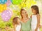 Happy woman and her little daughters in the park with ballons