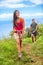 Happy woman hiker hiking couple in nature trek on hike trail on summer travel vacations. Healthy lifestyle young Asian