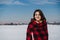 happy woman hiking outdoors in snowy mountain. Wrapped in plaid blanket. Nature and lifestyle