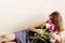 Happy woman hipster smelling peony bouquet lying on bed in the