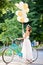 Happy woman holding baloons while riding bicycle