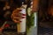 A happy woman holding cold mocktail glass with condensed water droplet during the evening in a restaurant warm weather in Bali