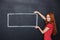 Happy woman holding drawn frame over chalkboard background