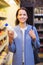 Happy woman holding milk bottle in market