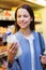 Happy woman holding milk bottle in market