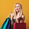 Happy woman holding shopping bags. Blonde girl enjoying seasonal sales. Shopping time. Consumerism, shopping, sales and lifestyle