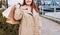 Happy Woman holding shopping paper bags in hands, walking at city street, black friday. Urban lifestyle concept