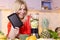 Happy woman holding tablet next to a juicer full of fruit