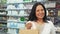 A happy woman holds a shopping bag and a credit card