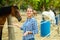 Happy woman horses breeder near stable