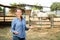 Happy woman horses breeder near stable