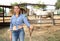 Happy woman horses breeder near stable