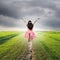 Happy woman jump in green rice fields and rainclouds