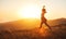 Happy woman jumping and enjoying life at sunset in mountains