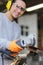 happy woman laborer cutting metal pipes