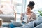 Happy woman, laptop and video call on home sofa with a smile and hand to wave hello. Real female person relax on a couch