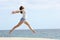 Happy woman with long legs jumping on the beach