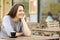 Happy woman looking away sitting on a coffee shop