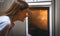 Happy woman looking into oven at cooking lunch