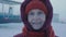 A happy woman looks at the camera and blinks. Aged female tourist traveling North Pole. Petrol station in the Arctic