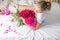 Happy woman lying on the bed wearing pajamas, enjoying tulip flowers bouquet of peony