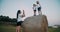 Happy woman make a photo of her little cute blondes kids on haystack in a field