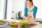 Happy woman making salad kitchen vegetables cooking