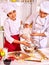 Happy woman and man in chef hat cooking dough