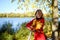 Happy woman with maple leaves in an autumn Park in a red jumpsuit