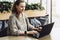 Happy woman millennial using laptop while sitting at cafe.Young businesswoman sitting in coffee shop,working on computer