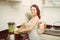 Happy woman mixing green vegetables in blender while preparing energetic cocktail