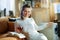 Happy woman near radiator and reading with tea cup