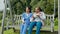 Happy woman, nurse and patient with coffee on swing or park bench in relax for healthcare in nature. Female person or