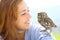 Happy woman with an owlet on her shoulder looks it