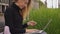 Happy woman paying online with credit card and tablet, sitting on bench.