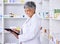 Happy woman, pharmacist and tablet for inventory inspection, stock or Telehealth at the pharmacy. Senior female person