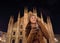 Happy woman with photo camera near Duomo in evening, Milan