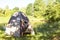 A happy woman in a plaid shirt looks out of a tourist tent on a hike on the riverbank in the morning. Camping in nature, overnight