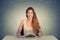 Happy woman with plate of salad, against gray wall background