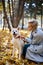 Happy woman play with big white pet dog akita inu in autumn forest, at sunny day.