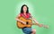 happy woman play the guitar. girl guitarist in shirt and jeans. country music style. attractive beauty with acoustic
