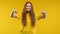 Happy woman pointing down to advertising area. Yellow background. Young lady asking to click to subscribe below. Copy