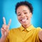 Happy woman, portrait smile and peace sign for selfie, photography or memory against a blue studio background. African